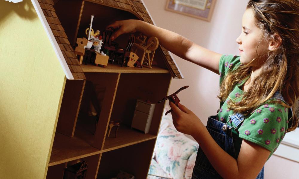 girl playing with dollhouse